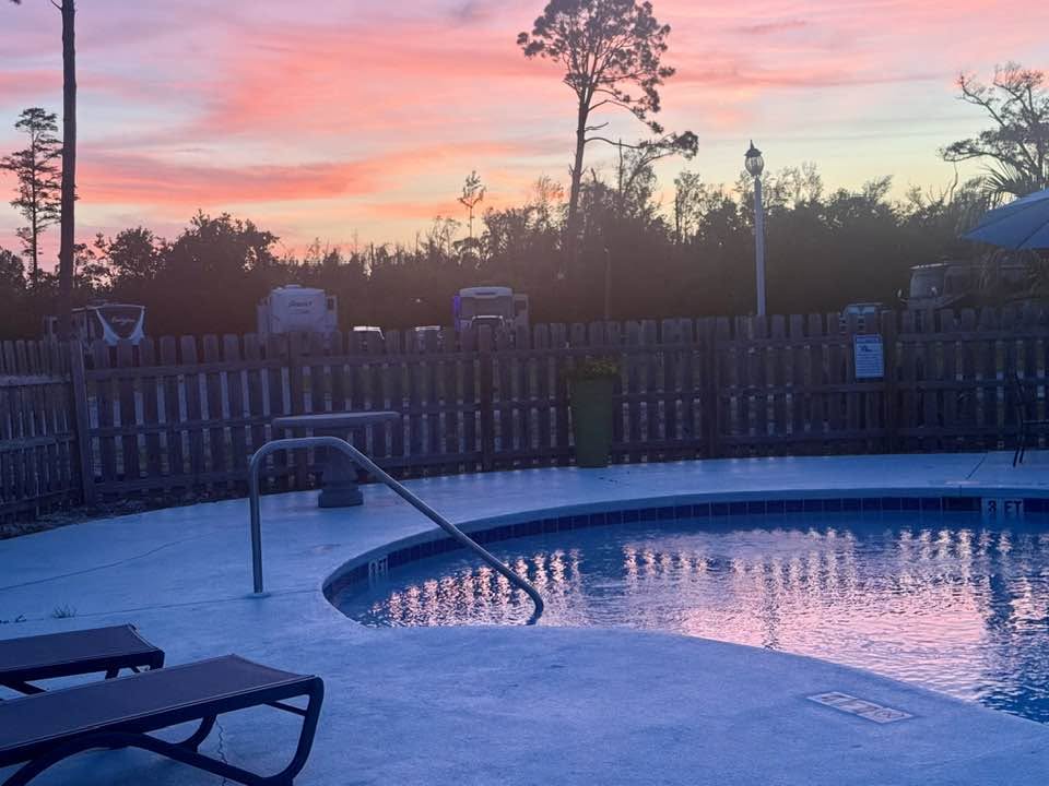 Resort pool under a pastel sunset sky