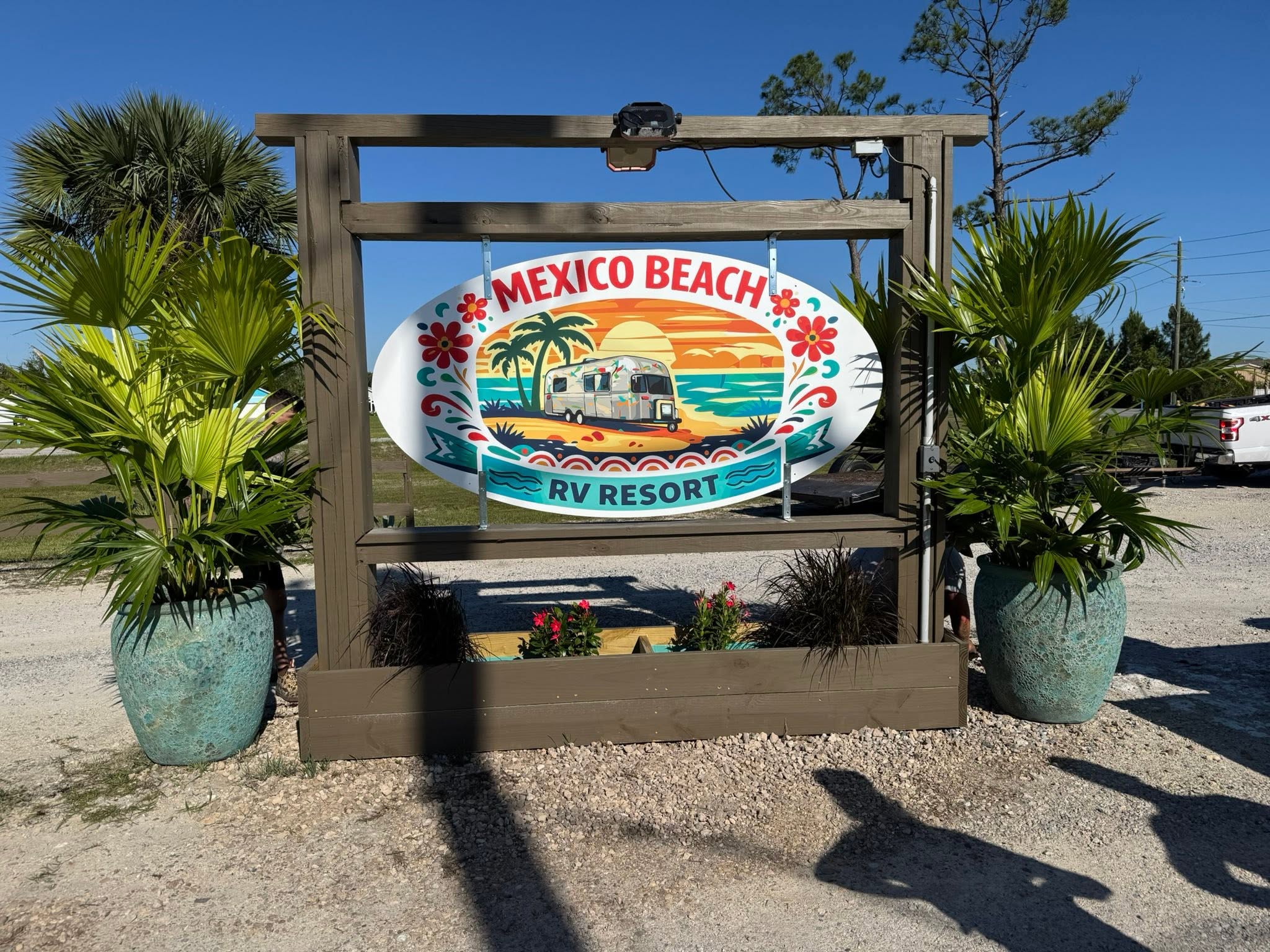 Mexico Beach RV Resort entrance sign surrounded by palms